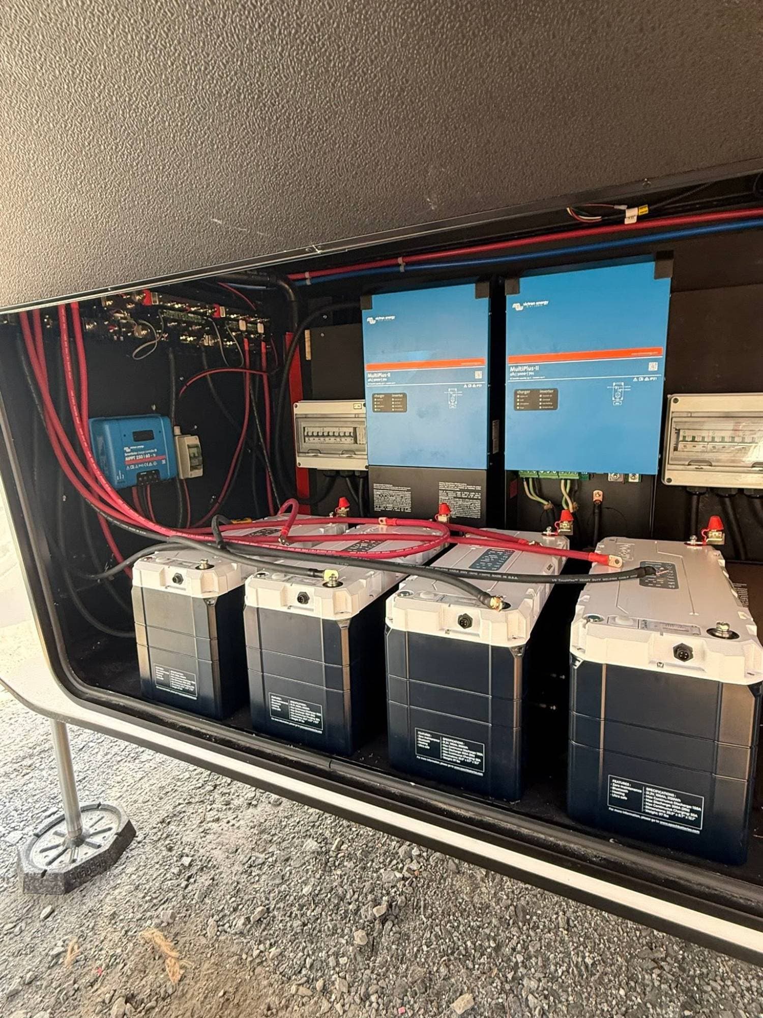Four Epoch 48V 100Ah heated Bluetooth LiFePO4 batteries in an RV basement bay, powering two Victron MultiPlus-II inverter chargers